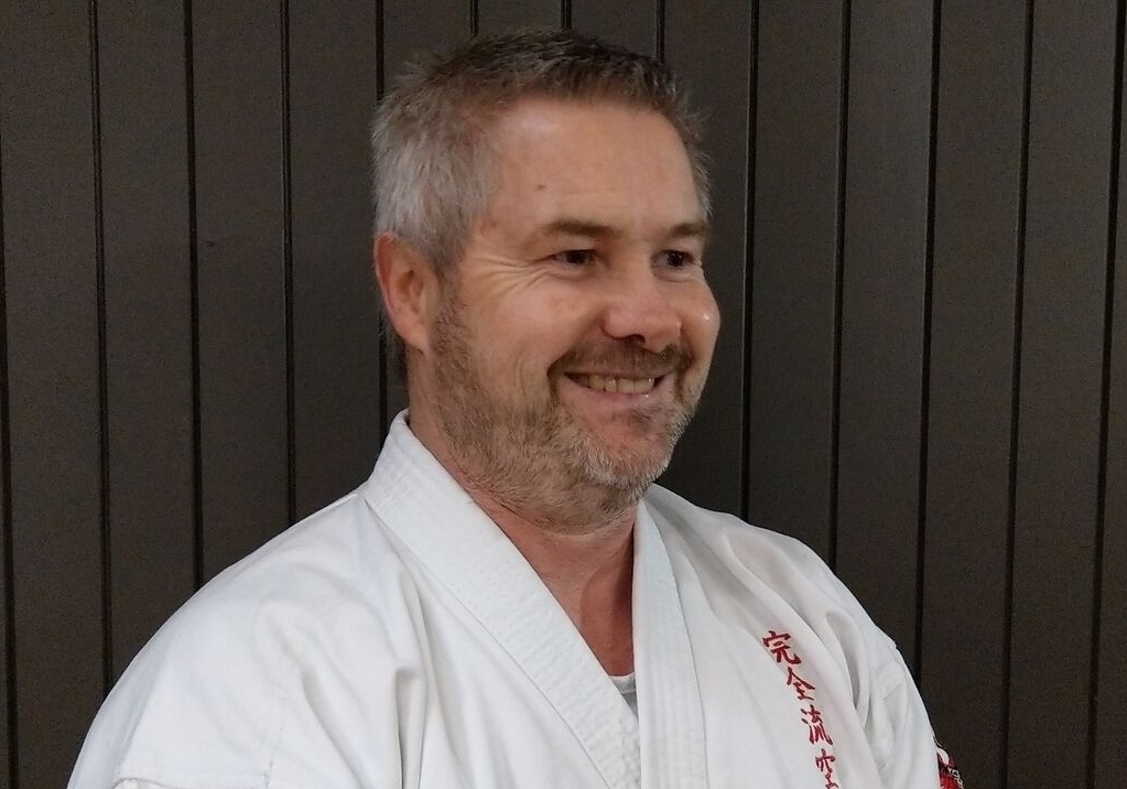 Kyoshi Tyraus Farrelly smiling at camera in karate gi